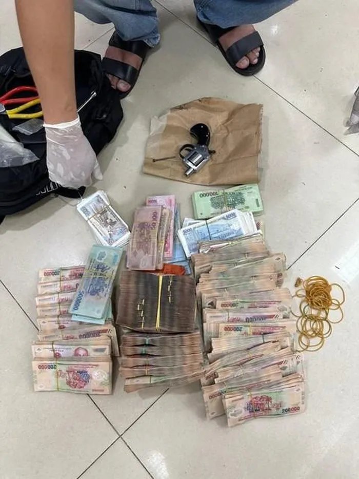 Súng và tiền tang vật.