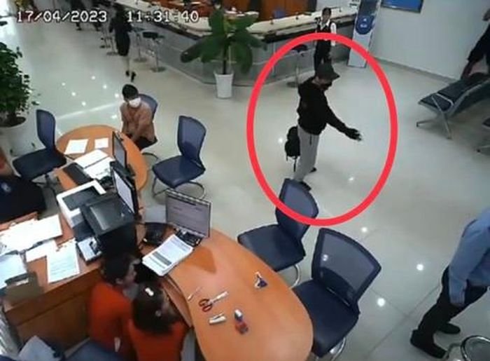 Đối tượng chỉa súng yêu cầu bảo vệ mở cửa.