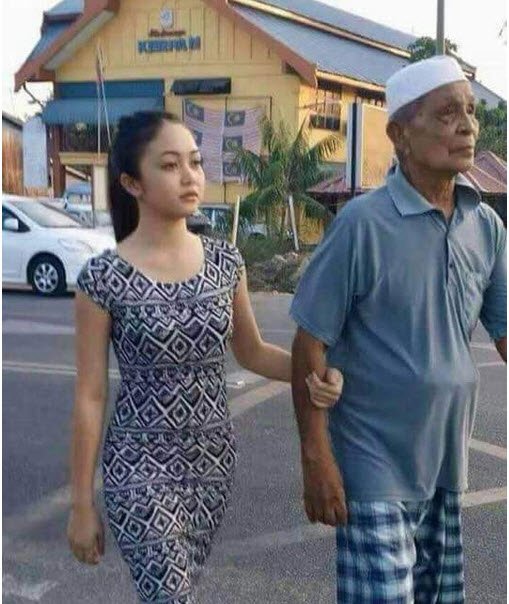 Cặp đôi “ông cháu” dắt tay nhau đi trên đường trước sự bàn tán không ngớt của những người xung quanh.